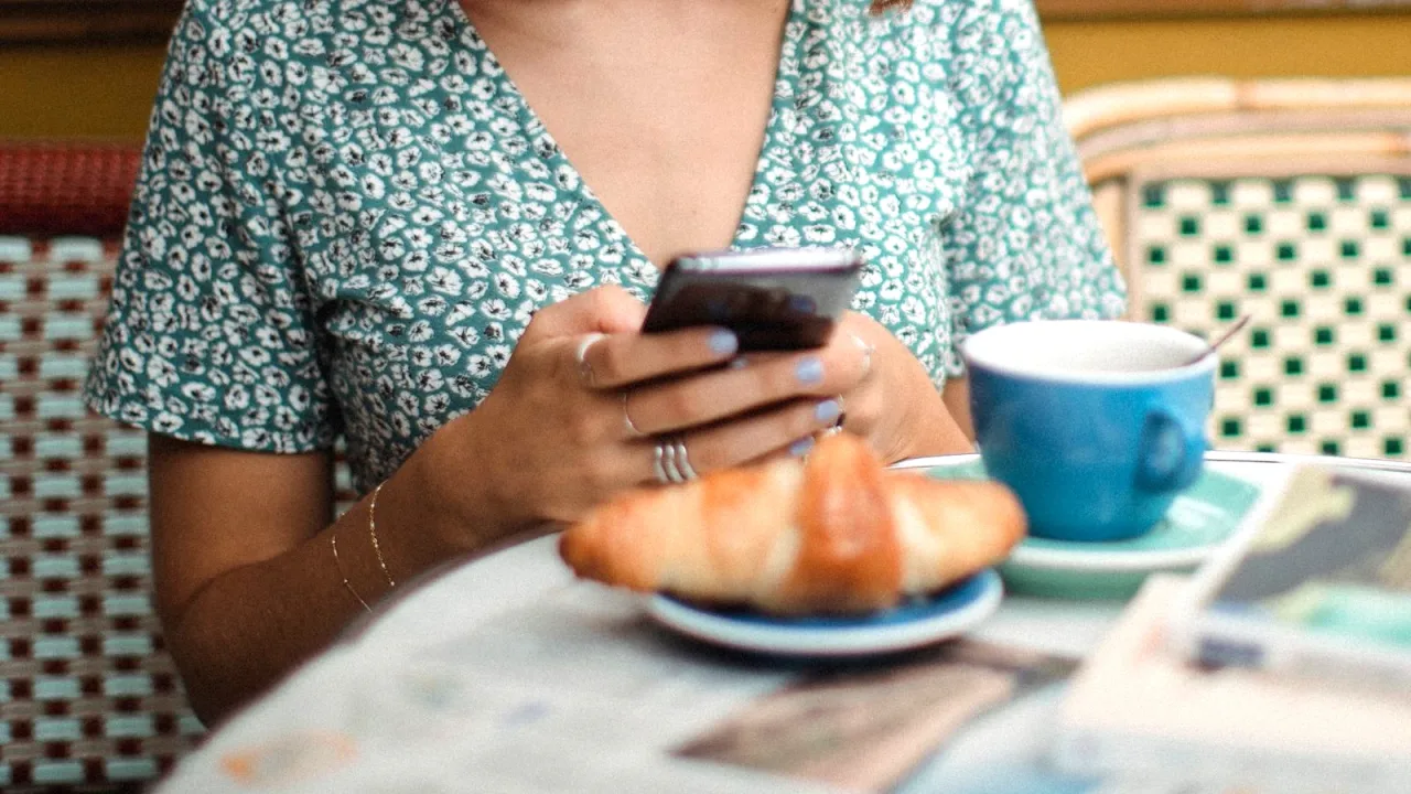 Kafede telefonundan haber okuyan kişi